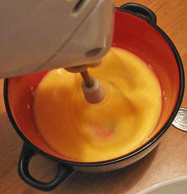 Взбиваем желтки для торта со сгущенкой и добавляем их к белкам